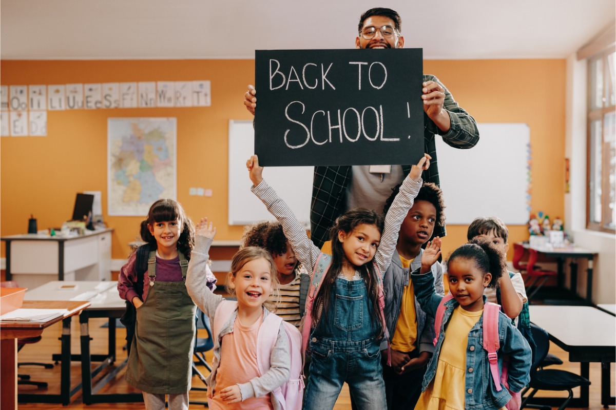 Teacher holding a Back To School Sign